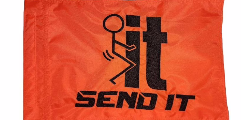 Fuck It Send It safety flag with black embroidered stick figure graphic and lettering on orange nylon rectangle