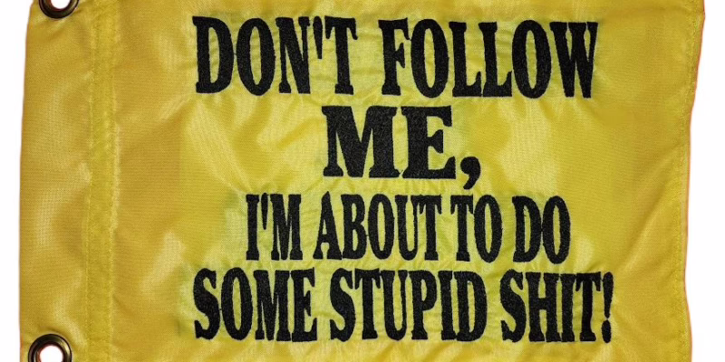 Don't follow me safety flag with dense embroidered black text on yellow nylon rectangle with solid brass grommets