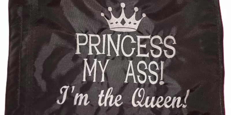 Princess My Ass I'm the Queen safety flag with silver embroidered crown and lettering on black nylon rectangle