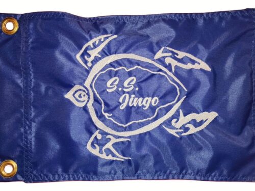 Sea Turtle safety flag with white embroidered petroglyph turtle and S.S. Jingo text on royal blue nylon rectangle with brass grommets