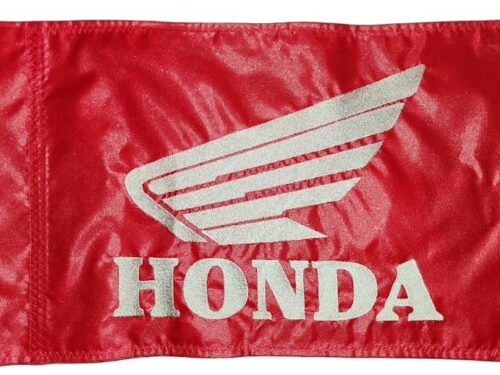 Honda safety flag with embroidered white wing logo and block lettering on red nylon rectangle with whip sleeve