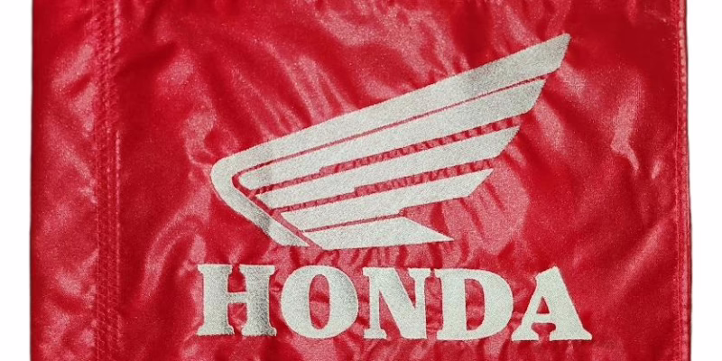 Honda safety flag with embroidered white wing logo and block lettering on red nylon rectangle with whip sleeve