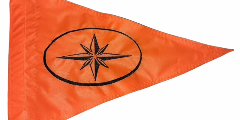 Compass Rose safety flag with embroidered black 8-point compass star in oval on safety orange nylon pennant with whip sleeve