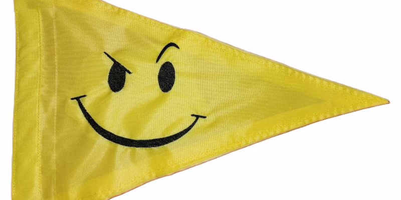 Smirky Face safety flag with black embroidered winking smirky face on yellow nylon pennant with whip sleeve