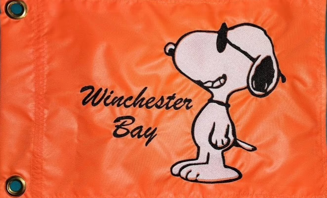 Snoopy safety flag with embroidered dog wearing sunglasses and Winchester Bay custom text on bright orange nylon rectangle with brass grommets