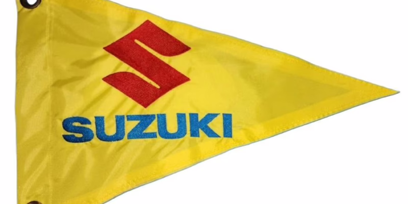 Suzuki safety flag with red embroidered S logo and electric blue Suzuki text on yellow nylon pennant with brass grommets
