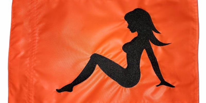 Mudflap Girl safety flag with black embroidered classic silhouette on orange nylon rectangle with whip sleeve