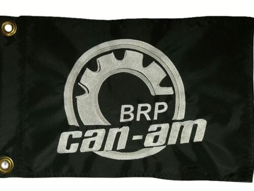 Can-Am safety flag with embroidered silver BRP gear logo and text on black nylon rectangle with brass grommets