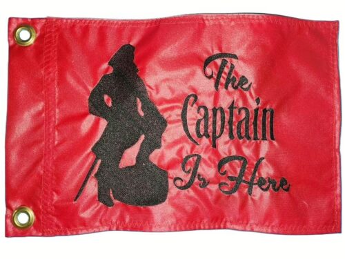 The Captain Is Here safety flag with dense embroidered pirate captain silhouette and script text on nylon rectangle with brass grommets
