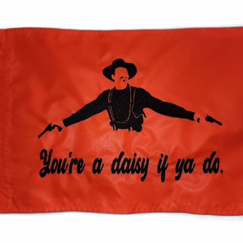 Doc Holliday safety flag with dense embroidered dual revolver gunslinger silhouette and You're a daisy if ya do text on nylon rectangle with brass grommets