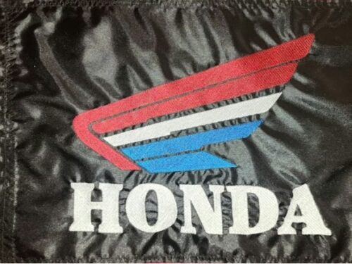 Honda safety flag with embroidered tri-color red white and blue wing emblem and block lettering on black nylon rectangle with whip sleeve