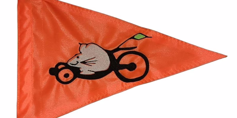 Recumbent Mouse safety flag with embroidered silver mouse pedaling a recumbent bike on bright orange nylon pennant with whip sleeve
