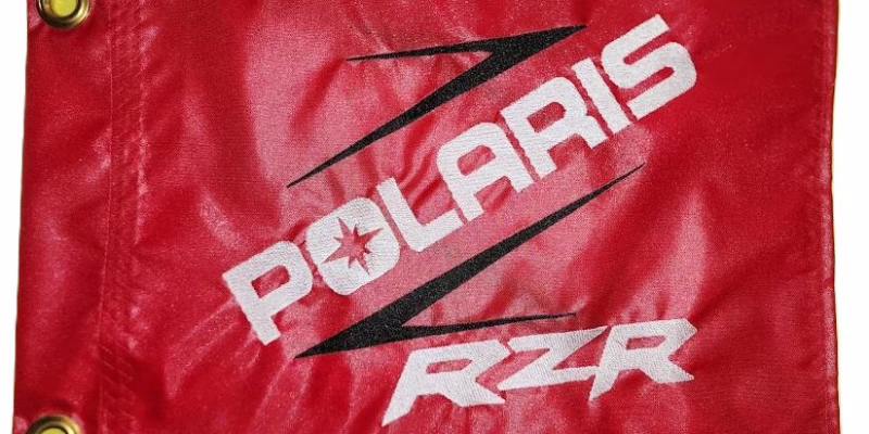 Polaris RZR safety flag with embroidered white lettering and black Z slash on red nylon rectangle with brass grommets