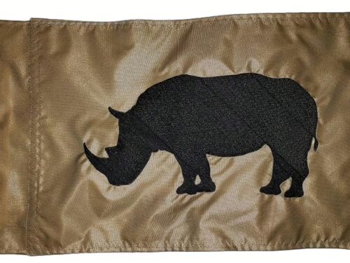 Tan rectangle safety whip flag featuring a dense embroidered black rhinoceros silhouette on heavy-duty nylon with a reinforced whip pole sleeve