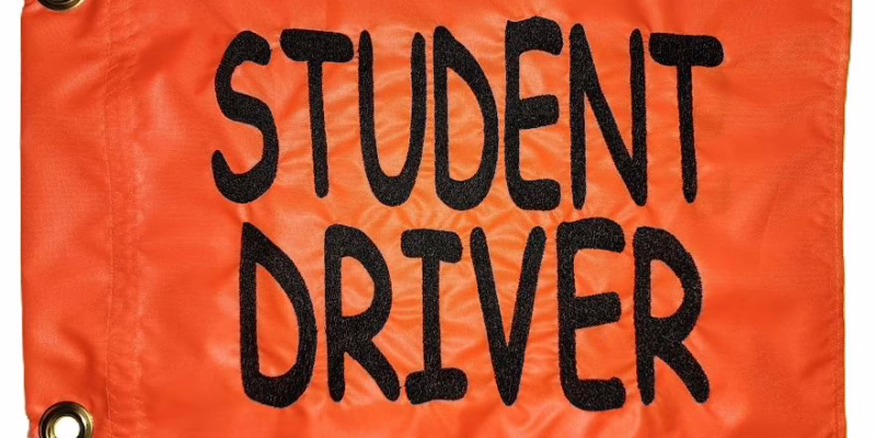 Student Driver safety flag with embroidered black stacked block lettering on bright orange nylon rectangle with brass grommets