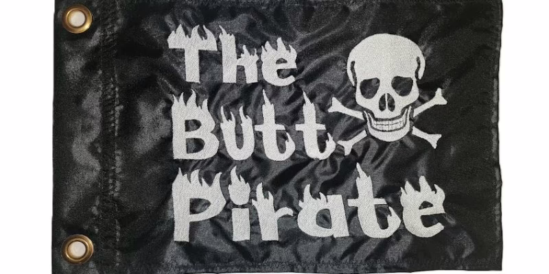 The Butt Pirate safety flag with white embroidered skull and flaming text on black nylon rectangle