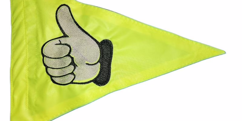 Thumbs up safety flag with dense embroidered white hand and black cuff on lime squeeze nylon pennant with whip sleeve