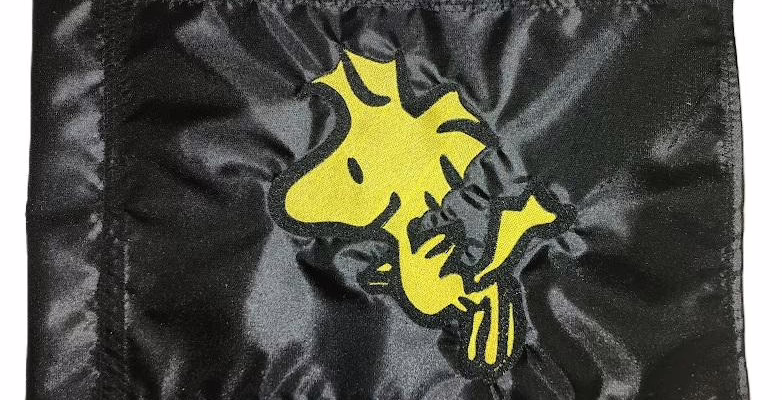 Woodstock safety flag with embroidered yellow bird on black nylon rectangle with whip sleeve