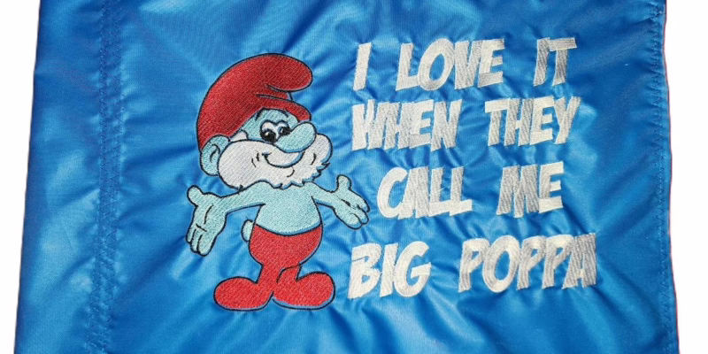 Papa Smurf safety flag with dense embroidered cartoon character and Big Poppa slogan on nylon rectangle with whip sleeve
