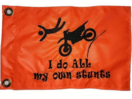 I Do All My Own Stunts dirt bike safety flag with embroidered flying rider and launching motorcycle on bright orange nylon rectangle with brass grommets