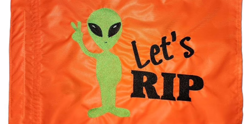 Alien Lets Rip safety flag with fluorescent green embroidered alien peace sign and black Lets Rip text on orange nylon rectangle with whip sleeve