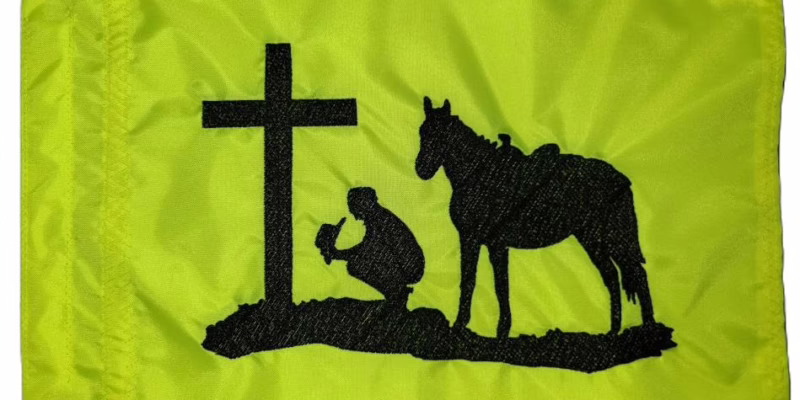 Praying cowboy at cross safety flag with dense embroidered black silhouette on lime squeeze nylon rectangle with whip sleeve