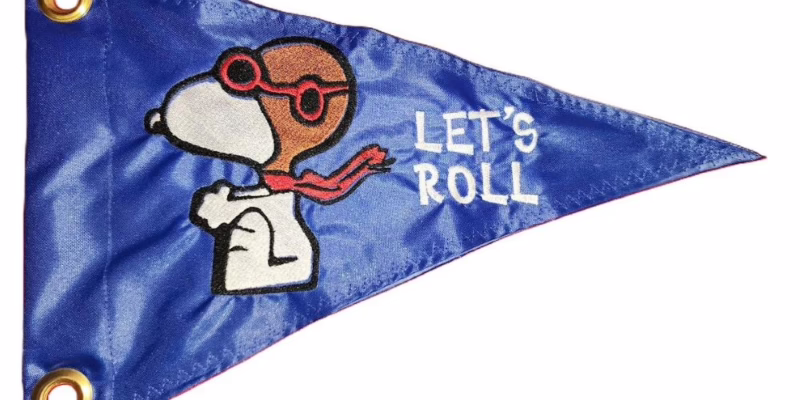 Flying Ace Snoopy safety flag with embroidered aviator dog on royal blue nylon pennant with brass grommets