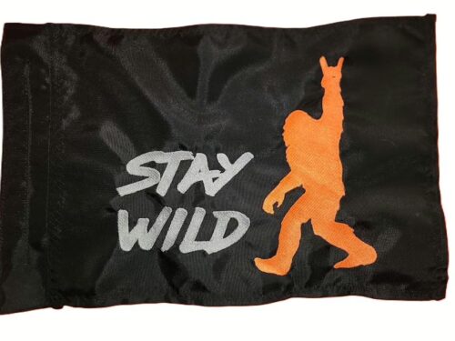Stay Wild safety flag with embroidered orange Bigfoot throwing horns and silver lettering on black nylon rectangle with whip sleeve