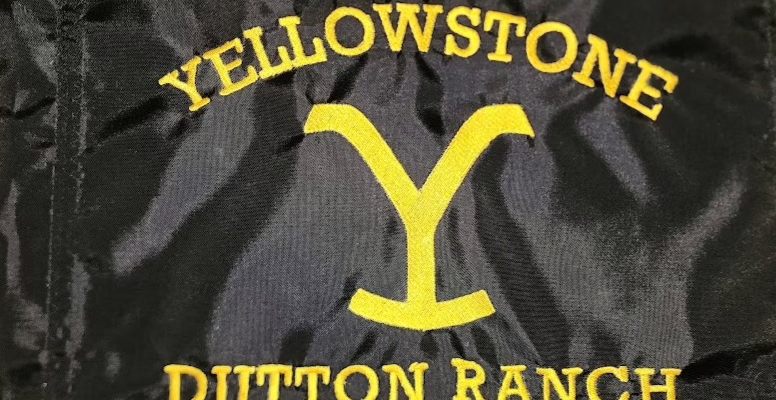 Yellowstone Dutton Ranch safety flag with dense embroidered yellow hooked Y brand and text on black nylon rectangle with whip sleeve
