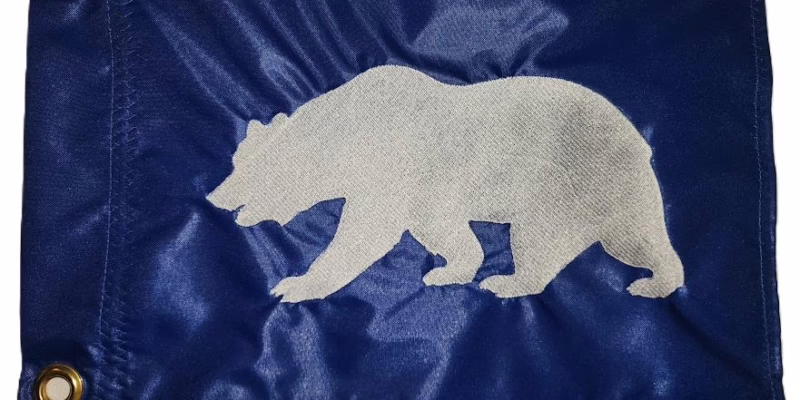 California Republic bear safety flag with dense embroidered white grizzly bear on royal blue nylon rectangle with solid brass grommets