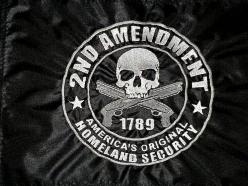 2nd Amendment safety flag with embroidered silver skull, crossed guns, and America's Original Homeland Security text on black nylon
