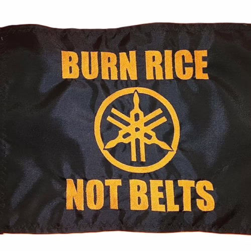 Personalized Yamaha safety flag with embroidered orange tuning forks logo and Burn Rice Not Belts text on black nylon rectangle with brass grommets