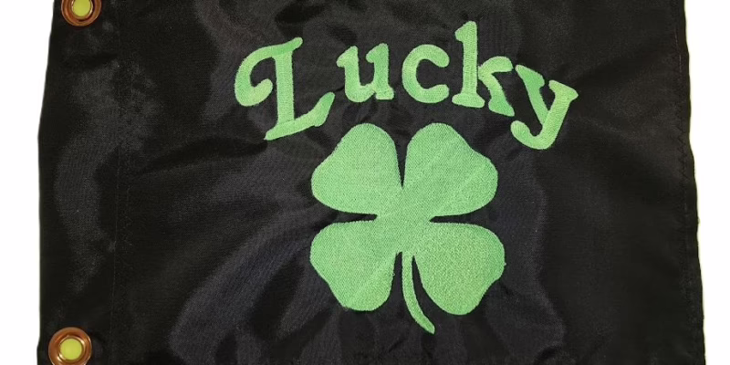 Lucky safety flag with dense embroidered fluorescent green four-leaf clover and "Lucky" text on black nylon rectangle with solid brass grommets