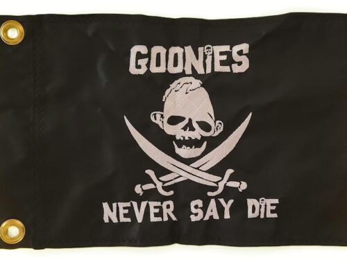 Sloth Never Say Die safety flag with dense embroidered silver skull emblem, crossed cutlasses, and custom movie text on black nylon rectangle with solid brass grommets