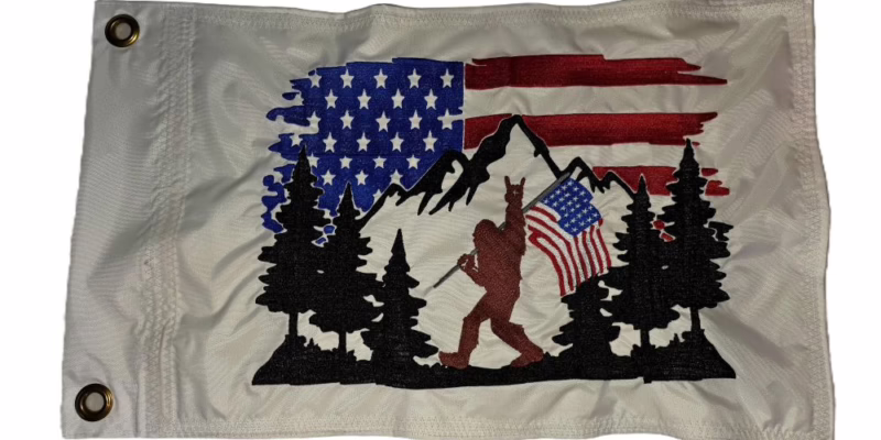 Bigfoot American flag safety flag with embroidered mountains trees and patriotic banner on white nylon rectangle with brass grommets