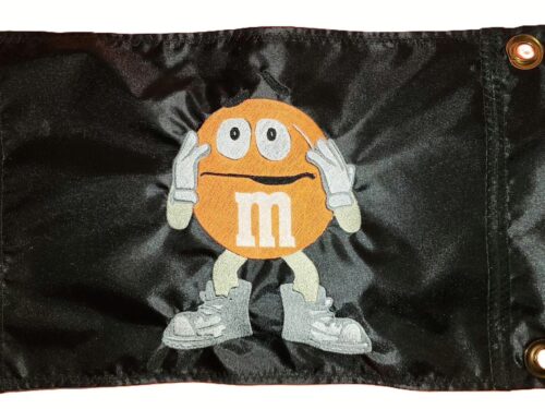 Worried M&M safety flag with dense embroidered anxious candy mascot on nylon rectangle with brass grommets