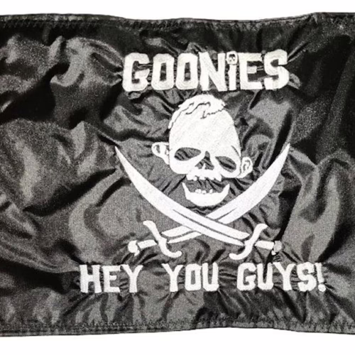 The Goonies Hey You Guys safety flag with dense embroidered silver skull emblem and movie quote text on black nylon rectangle with whip sleeve