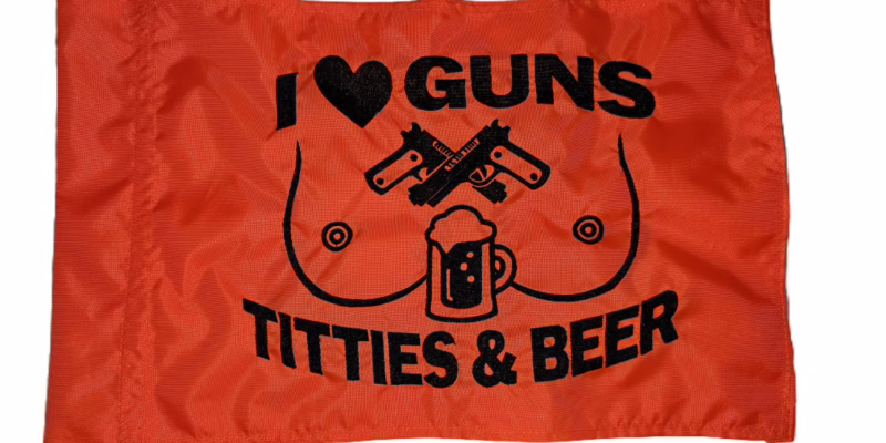 I Heart Guns Titties and Beer safety flag with black embroidered text and graphics on orange nylon rectangle